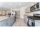 Modern kitchen boasts stainless steel appliances, granite countertops, and gray cabinetry at 7211 Alabaster Peak St, Las Vegas, NV 89166
