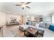 Open-concept living room with plush sectional sofa, adjacent kitchen and dining areas bathed in natural light at 7211 Alabaster Peak St, Las Vegas, NV 89166