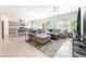 Bright living room with tile floors, a gray sectional sofa, ceiling fan, and an open layout to the kitchen at 7211 Alabaster Peak St, Las Vegas, NV 89166