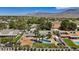 Expansive aerial view of a home with a pool, horse property, RV parking, mature landscaping, and mountain views at 7675 Butterscotch Ct, Las Vegas, NV 89131