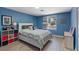 Well-lit bedroom featuring blue walls, hardwood floors, a window, and storage space at 7675 Butterscotch Ct, Las Vegas, NV 89131