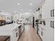 Modern kitchen with an open view to the living space with white cabinets, stainless steel appliances, and quartz countertops at 7675 Butterscotch Ct, Las Vegas, NV 89131