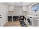 Clean laundry room with a washing machine, dryer, white cabinets, and hardwood floors at 7675 Butterscotch Ct, Las Vegas, NV 89131