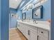 Charming main bathroom with dual sinks, white cabinets, and hardwood floors at 7675 Butterscotch Ct, Las Vegas, NV 89131