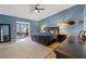 Spacious main bedroom features blue walls, hardwood floors, a ceiling fan, and an ensuite bathroom at 7675 Butterscotch Ct, Las Vegas, NV 89131