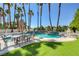 Outdoor seating around backyard pool with lawn area, mature landscaping, and tall palm trees at 7889 Rancho Mirage Dr, Las Vegas, NV 89113