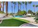 Inviting backyard pool featuring palm trees, a lounge area, manicured turf and plenty of space for entertaining at 7889 Rancho Mirage Dr, Las Vegas, NV 89113