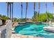 Resort-style pool features multi-tiered design, tall palm trees, and privacy landscaping at 7889 Rancho Mirage Dr, Las Vegas, NV 89113