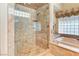 Marble tiled stand-up shower with built in seat and natural lighting with adjacent bathtub at 7889 Rancho Mirage Dr, Las Vegas, NV 89113
