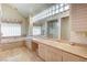 Bright bathroom featuring marble countertops, bathtub and shower, and natural wood cabinets at 7889 Rancho Mirage Dr, Las Vegas, NV 89113