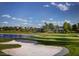Scenic golf course with a pond and sand trap, surrounded by lush landscaping and beautiful homes at 7889 Rancho Mirage Dr, Las Vegas, NV 89113