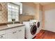 Well-equipped laundry room with modern washer and dryer, storage cabinets, and natural light at 7889 Rancho Mirage Dr, Las Vegas, NV 89113