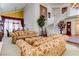 Spacious living room with staircase, elegant decor, and comfortable floral sofas at 7889 Rancho Mirage Dr, Las Vegas, NV 89113