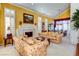 Inviting living room with a fireplace, shuttered windows, and comfortable floral sofas at 7889 Rancho Mirage Dr, Las Vegas, NV 89113