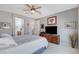 Neutral-toned main bedroom with a ceiling fan, dresser with TV, and access to an ensuite bathroom at 8286 Skye Gorge St, Las Vegas, NV 89166