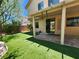Artificial turf lawn, providing a low-maintenance outdoor space, and a covered patio for relaxing and entertaining at 9052 Pine Mission Ave, Las Vegas, NV 89143