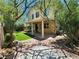 Backyard featuring a covered patio, artificial grass, and mature trees, perfect for relaxing and entertaining at 9052 Pine Mission Ave, Las Vegas, NV 89143