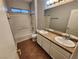 Bathroom featuring a double sink vanity with a tiled countertop, tiled floor, and shower over tub at 9052 Pine Mission Ave, Las Vegas, NV 89143