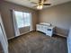 Cozy bedroom with a ceiling fan, large window, and a white crib, perfect for a Bedroom at 9052 Pine Mission Ave, Las Vegas, NV 89143