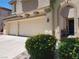 Tan home featuring a three-car garage, desert landscaping, and an arched entry way at 9052 Pine Mission Ave, Las Vegas, NV 89143