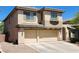 Side view of a tan two-story home featuring a three-car garage and desert landscaping at 9052 Pine Mission Ave, Las Vegas, NV 89143