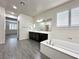 Bright primary bathroom with a large soaking tub, double vanity, and wood-look tile flooring at 907 Gallery Course Dr, Las Vegas, NV 89148