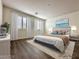 Bright bedroom featuring wood floors, a neutral color palette, and shuttered windows at 907 Gallery Course Dr, Las Vegas, NV 89148