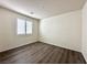 Neutral bedroom featuring wood-look floors, window with shutter and plenty of sunlight at 907 Gallery Course Dr, Las Vegas, NV 89148