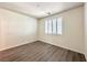 Neutral bedroom featuring wood-look floors, window with shutter and a light at 907 Gallery Course Dr, Las Vegas, NV 89148