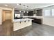 Open-concept kitchen with granite countertops, stainless appliances, and gray wood flooring at 907 Gallery Course Dr, Las Vegas, NV 89148
