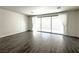 Well-lit living room with wood-look tile flooring and sliding glass doors at 907 Gallery Course Dr, Las Vegas, NV 89148