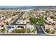 Wide aerial view of homes, palm trees, and mature landscaping within a gated Las Vegas community at 9155 Harvest Homes St, Las Vegas, NV 89123