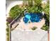 Aerial view of a private backyard oasis with a sparkling pool, lush landscaping, and ample patio space for entertaining at 9155 Harvest Homes St, Las Vegas, NV 89123