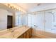 Bathroom featuring double sinks, a large mirror, and a bathtub with glass enclosure at 9155 Harvest Homes St, Las Vegas, NV 89123