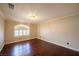 An empty bedroom with hardwood floors, white trim, and a large window with plantation shutters at 9155 Harvest Homes St, Las Vegas, NV 89123
