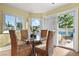 Bright breakfast nook with a glass table, four woven chairs, and views of the well-manicured backyard at 9155 Harvest Homes St, Las Vegas, NV 89123