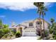 Elegant two-story home with a three-car garage, balcony, and a beautifully landscaped front yard with mature trees at 9155 Harvest Homes St, Las Vegas, NV 89123