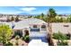 Charming two-story home featuring a well-manicured lawn, palm trees, a balcony, and a three-car garage at 9155 Harvest Homes St, Las Vegas, NV 89123