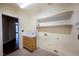 Bright laundry room includes built-in shelves and a sink with cabinet storage, perfect for organization and convenience at 9155 Harvest Homes St, Las Vegas, NV 89123