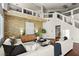 Open-concept living room featuring hardwood floors, a modern sectional sofa, and a stone accent wall at 9155 Harvest Homes St, Las Vegas, NV 89123