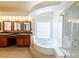 Well-lit main bathroom with double vanity, soaking tub, glass shower, and neutral color palette at 9155 Harvest Homes St, Las Vegas, NV 89123