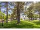 Relaxing community park featuring tall trees, green grass and picnic tables on a sunny day at 9155 Harvest Homes St, Las Vegas, NV 89123