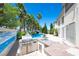 Outdoor kitchen, BBQ and inviting backyard pool with tropical landscaping and waterfall at 9155 Harvest Homes St, Las Vegas, NV 89123