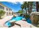 Resort-style backyard featuring a sparkling pool, rock features, lush landscaping, and ample patio space for entertaining at 9155 Harvest Homes St, Las Vegas, NV 89123