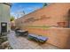Outdoor patio features paving stones, a seating and lounge area and tall brick wall at 9715 Aleutian St, Las Vegas, NV 89178