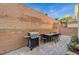 Outdoor patio with paving stones features a built-in barbecue, outdoor dining set and tall brick wall at 9715 Aleutian St, Las Vegas, NV 89178