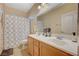 Well-lit bathroom features dual sinks, neutral colors, and a shower with a curtain at 9715 Aleutian St, Las Vegas, NV 89178
