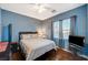 Bedroom features a queen bed, hardwood floors, blue walls, and natural lighting at 9715 Aleutian St, Las Vegas, NV 89178