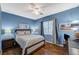Comfortable bedroom showcases natural light, blue walls, and stylish hardwood flooring at 9715 Aleutian St, Las Vegas, NV 89178