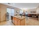 Open floor plan kitchen and living room area with granite island and stainless refrigerator at 9715 Aleutian St, Las Vegas, NV 89178